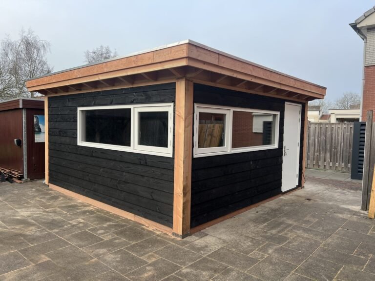 Een tuinhuis met een zwarte gevel