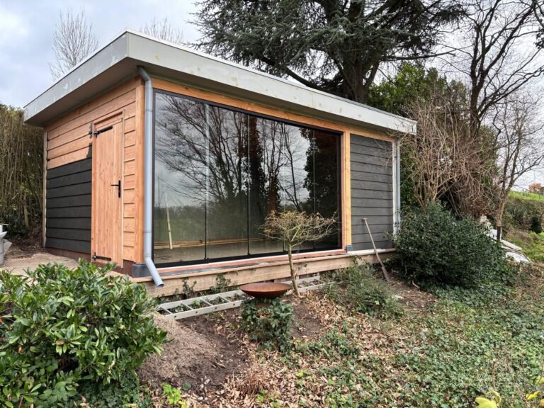 Een tuinkamer met een grote glazen pui