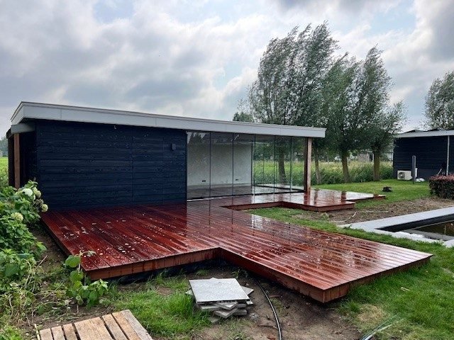 Een tuinkamer met een houten vlonder
